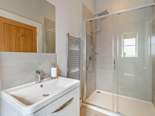 a white bathroom with a sink and a shower at 2 Bed in Auchterarder 94546 in Auchterarder