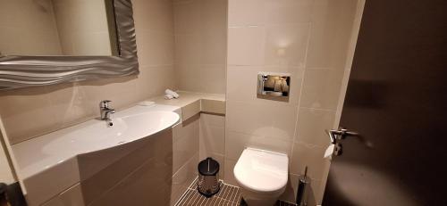 a bathroom with a sink and a toilet and a mirror at Radisson Blu Hotel, Addis Ababa in Addis Ababa