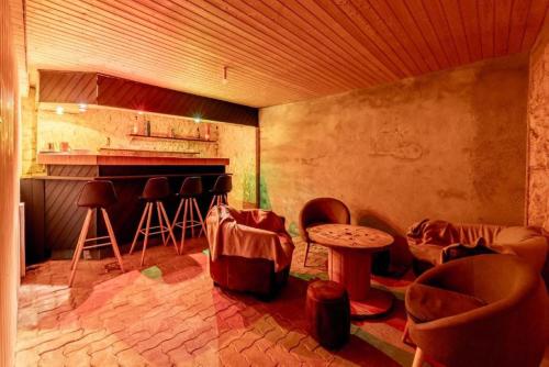 a room with a bar with chairs and a table at Gîte Refuge des Amis in La Gaubretière