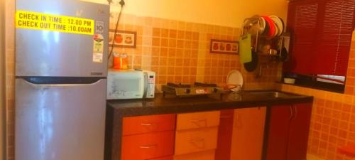 a kitchen with a refrigerator and a sink at 2 BHK resort apat with Pool Near Candolim Beach AC WIFI in Goa