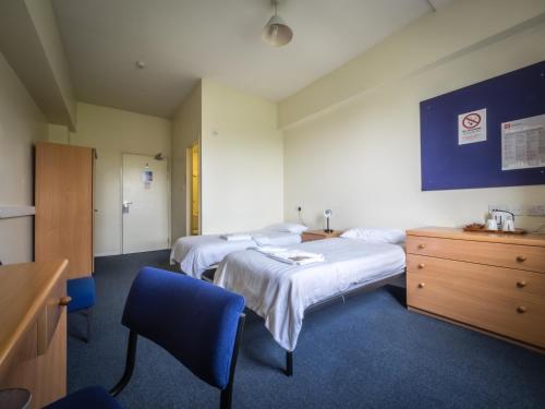 a hospital room with two beds and a dresser at LSE Bankside House in London