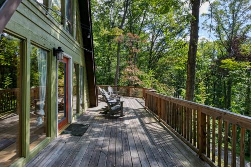 a wooden deck with a bench on the side of a house at Honeycomb Hideaway by AvantStay Rustic Retreat in Fairview