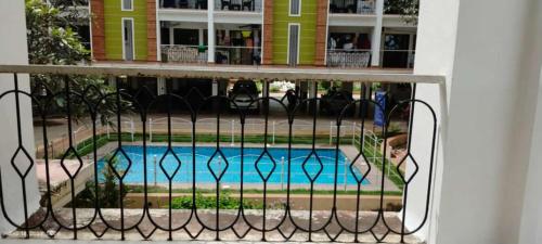a fence with a pool in front of a building at 2 BHK resort apat with Pool Near Candolim Beach AC WIFI in Goa