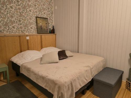 a small bed in a room with a bench at Tohninmäen Talo in Töysä