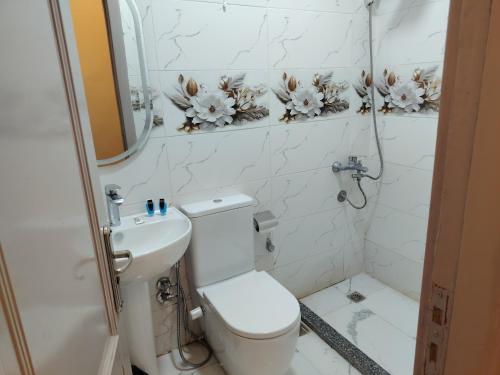 a white bathroom with a toilet and a sink at Red Pyramids Hotel in Cairo