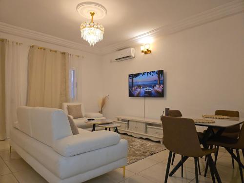 - un salon avec un canapé blanc et une télévision murale dans l'établissement Résidence-MDKM, à Abidjan