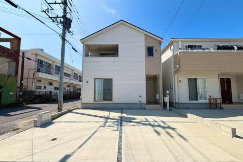 a white building on the side of a street at ZZOKIAI 橙霞 30-seconds walk to the seaside!4LDK maximun 10 people! in Itoman