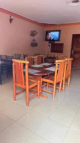 a dining room with a table and chairs and a television at Highland hotel kapchorwa in Kapchorwa