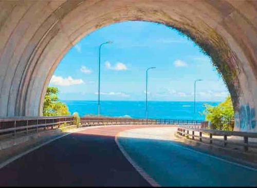 a tunnel with a view of the ocean through it at ZZOKIAI 橙霞 30-seconds walk to the seaside!4LDK maximun 10 people! in Itoman