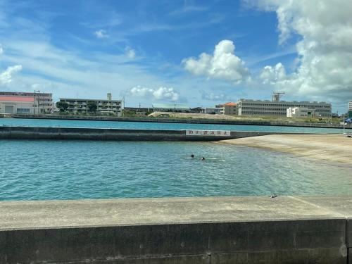two people swimming in a body of water at ZZOKIAI 橙霞 30-seconds walk to the seaside!4LDK maximun 10 people! in Itoman