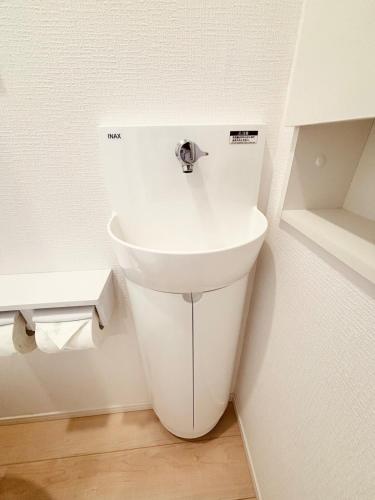 a white toilet in a corner of a bathroom at ZZOKIAI 橙霞 30-seconds walk to the seaside!4LDK maximun 10 people! in Itoman