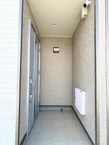 a bathroom with a walk in shower and a tile wall at ZZOKIAI 橙霞 30-seconds walk to the seaside!4LDK maximun 10 people! in Itoman