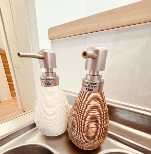 two faucets sitting on top of a kitchen sink at ZZOKIAI 橙霞 30-seconds walk to the seaside!4LDK maximun 10 people! in Itoman