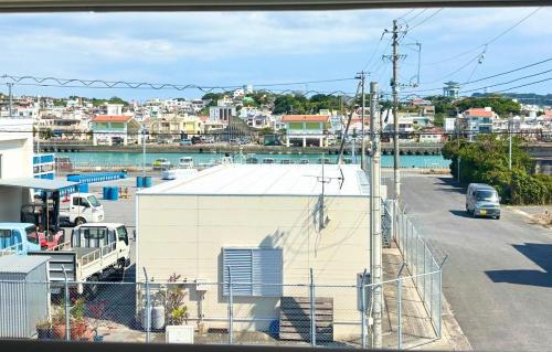 a view of a harbor with a building and a car at ZZOKIAI 橙霞 30-seconds walk to the seaside!4LDK maximun 10 people! in Itoman