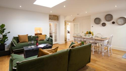 salon z zielonymi meblami i jadalnią w obiekcie Sage Cottage w mieście Blockley