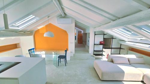 een woonkamer met een witte bank en een tafel bij La Mansarda di Via Niella in Savona
