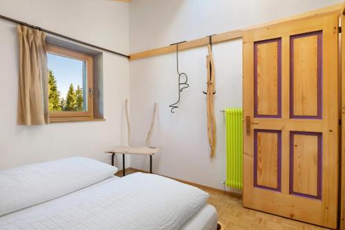 a bedroom with two beds and a window and a door at Kesselmoos in Nova Ponente