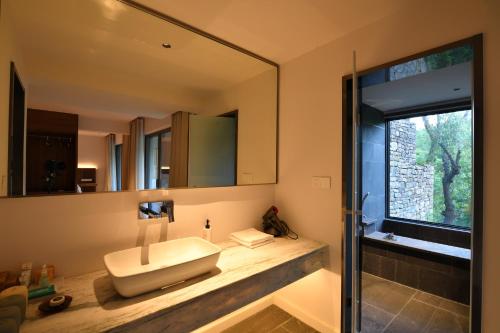 a bathroom with a sink and a mirror at 至也 黄果树 in Xinggong