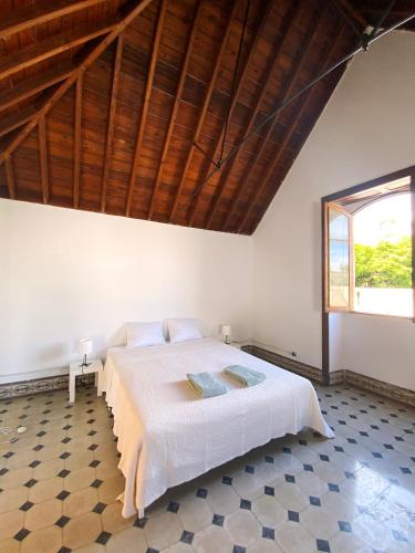 a bedroom with a large bed with a wooden ceiling at Comfortable Room in Historic Casa Quesada Shared House in Las Palmas de Gran Canaria