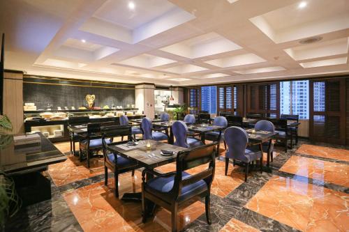 a restaurant with tables and chairs and a bar at Wyndham Casablanca Jakarta in Jakarta