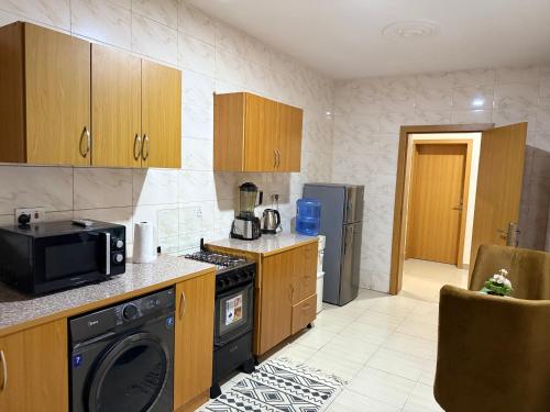 a kitchen with a stove and a microwave at Luxury 2-bed w 24h light in Magodo GRA Phase 2 in Sagisa