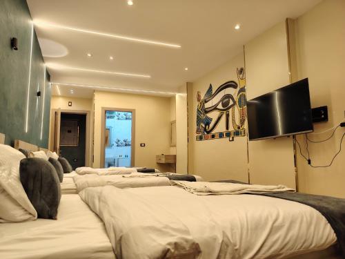 a row of beds in a room with a flat screen tv at Red Pyramids Hotel in Cairo