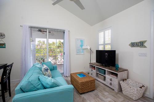 a living room with a blue couch and a television at Ports of Call Resort in Grace Bay