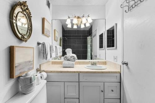 a white bathroom with a sink and a mirror at Top Of The Gulf 507 Beach Front Resort Ocean View in Panama City Beach
