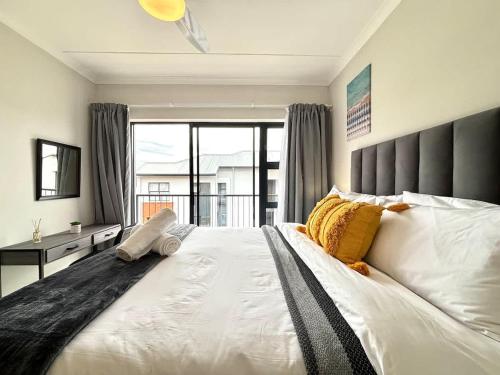 a bedroom with a large bed with a large window at The Pearl in Ballito