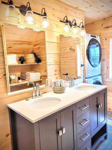 a bathroom with two sinks and a mirror at Saltwater, ocean views and sunsets in Chéticamp