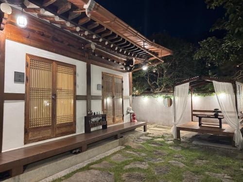 a building with a bench and a tent at night at Pungnam House in Jeonju