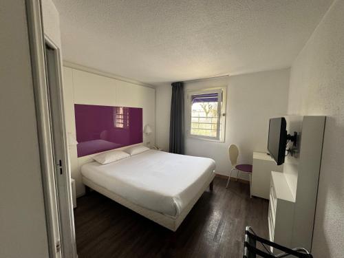 a bedroom with a white bed and a window at Tulip Inn Beaune in Beaune