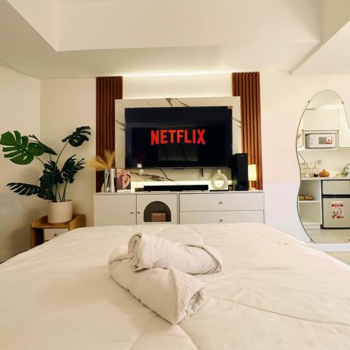1 dormitorio con 1 cama y TV en Azure North Pampanga Staycation, en San Fernando