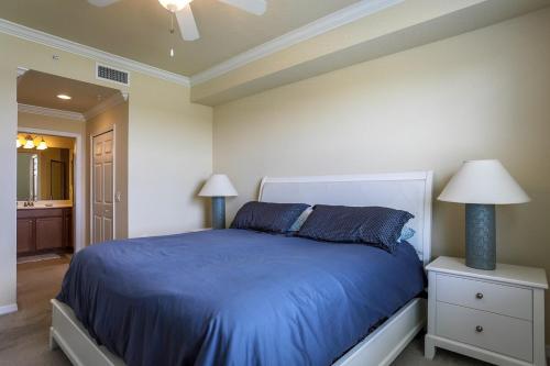 - une chambre avec un lit bleu et deux lampes dans l'établissement Second Floor River Strand Condo Overlooking the Golf Course - Sunny Life, à Marsh Island