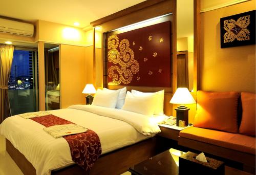 a hotel room with a large bed and a couch at Mariya Boutique Hotel At Suvarnabhumi Airport in Lat Krabang