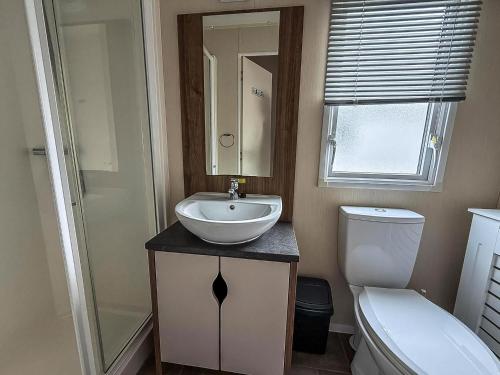 a bathroom with a sink and a toilet at Caravan With Large Decking At Coopers Beach Holiday Park Ref 49012Sv in East Mersea