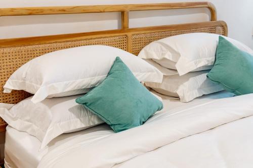 two pillows on a bed with white and green pillows at BRAND NEW! 2BR Villa in SouthKuta With Pool in Ungasan