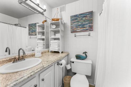 une salle de bain blanche avec un lavabo et des toilettes dans l'établissement Top Of The Gulf 620 Beachfront Couples Retreat, à Panama City Beach