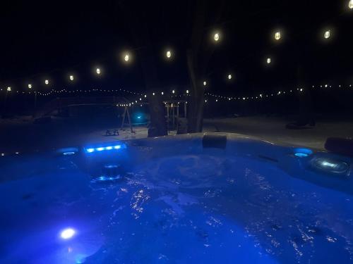 Una piscina de noche con luces azules en Spacious 5BR Getaway, Hot Tub, Cozy Vibes, 