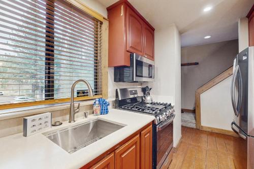 una cocina con fregadero y estufa en Aspen Grove Getaway, en Kingswood Estates