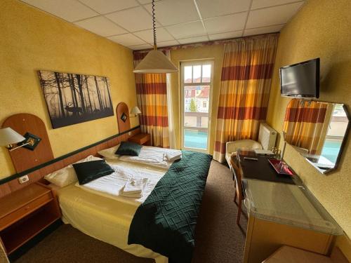 a hotel room with a bed and a desk at Hotel Deutsche Hof in Georgenthal