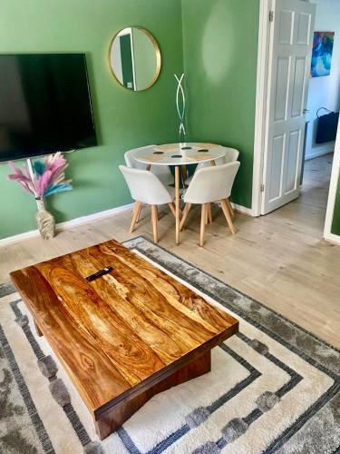a living room with a wooden table and a dining room at 3 bedroom apartment in Cumbernauld