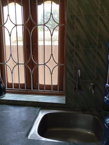 a sink in front of a window with a door at Birsa Munda Airport Nature Nook in Rānchī