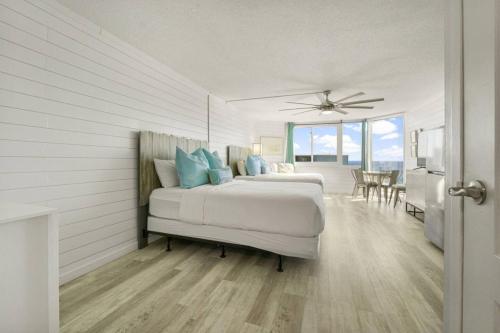 a bedroom with two beds and a dining room at Sea The Gulf - Top Of The Gulf 809 - Luxury Resort in Panama City Beach