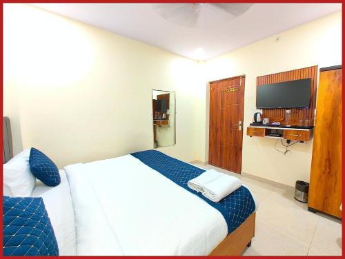 a hotel room with a bed and a television at Hotel New Kashi - Grand Near Vishwanath Temple - Fully Air Conditioned Rooms - #Restaurant #Wi-fi #Lift # Parking Facilities - A Top Rated Hotel in Varanasi
