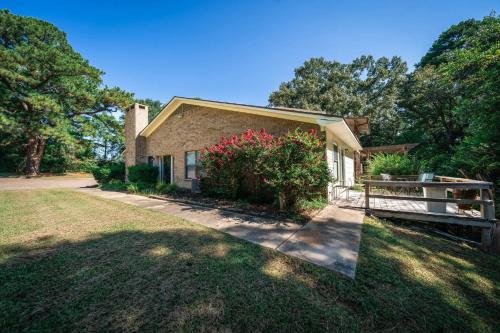 a house with a fence in front of a yard at Woodland Springs in Gladewater