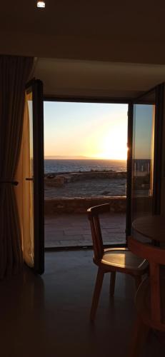 a chair in a room with a view of the ocean at Mani Sol Apartments in Kotrónion
