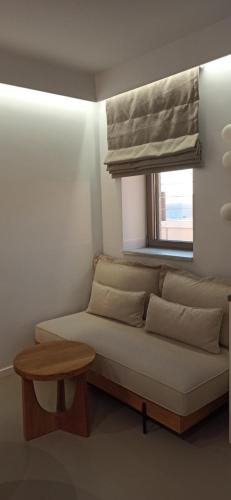 a bed in a room with a window and a couch at Mani Sol Apartments in Kotrónion