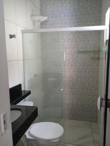 a bathroom with a shower with a toilet and a sink at Espaço Marques in Porto Seguro
