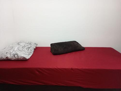 a red bed with two pillows on top of it at Espaço Marques in Porto Seguro